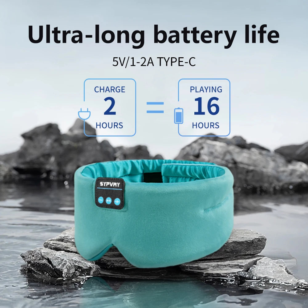 Teal sleep mask with charging information on a rock by water
